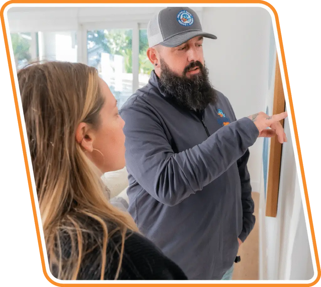 Reliable Ducts technician explaining AC repair to Jacksonville homeowner during service call