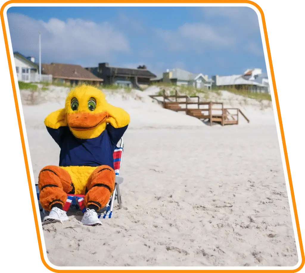 Reliable Ducts mascot relaxing on the sand in Atlantic Beach, FL to promote trusted local AC repair and HVAC services